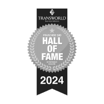 Black and white ribbon badge with a laurel wreath, displaying the text "Transworld Business Advisors Franchise 500 Hall of Fame 2024" by Entrepreneur Magazine.